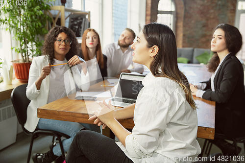 Image of Group of young business professionals having a meeting, creative office