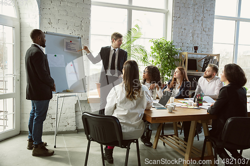 Image of Group of young business professionals having a meeting, creative office