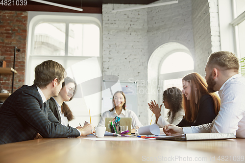 Image of Group of young business professionals having a meeting, creative office