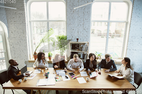 Image of Group of young business professionals having a meeting, creative office