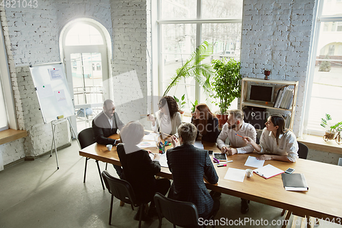 Image of Group of young business professionals having a meeting, creative office
