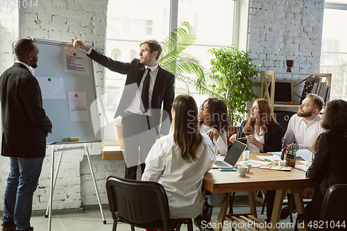 Image of Group of young business professionals having a meeting, creative office