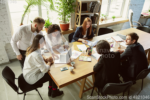 Image of Group of young business professionals having a meeting, creative office