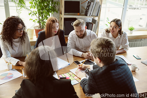 Image of Group of young business professionals having a meeting, creative office