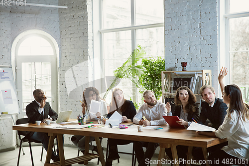 Image of Group of young business professionals having a meeting, creative office