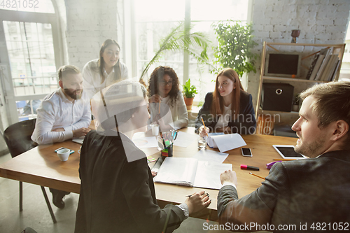 Image of Group of young business professionals having a meeting, creative office