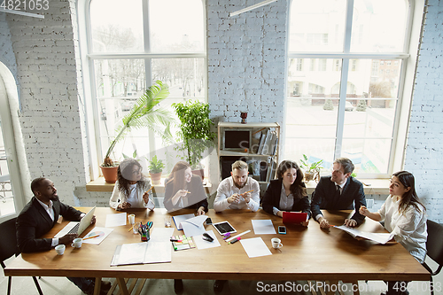 Image of Group of young business professionals having a meeting, creative office