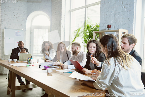 Image of Group of young business professionals having a meeting, creative office