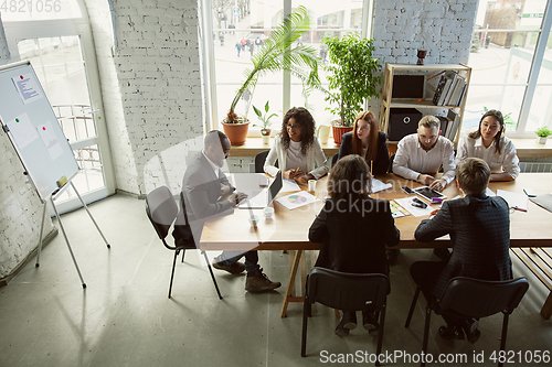 Image of Group of young business professionals having a meeting, creative office