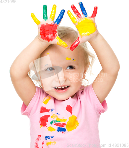 Image of Portrait of a cute little girl playing with paints