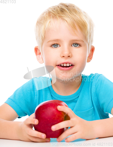 Image of Portrait of a cute little boy with red apple