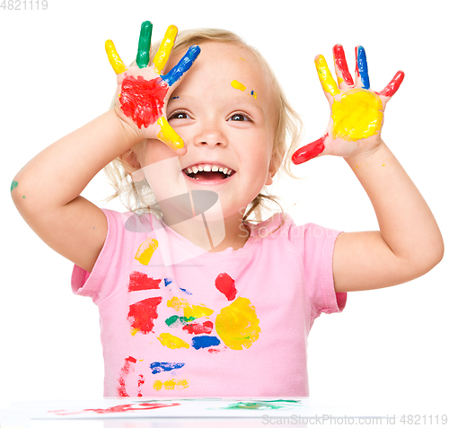 Image of Portrait of a cute little girl playing with paints