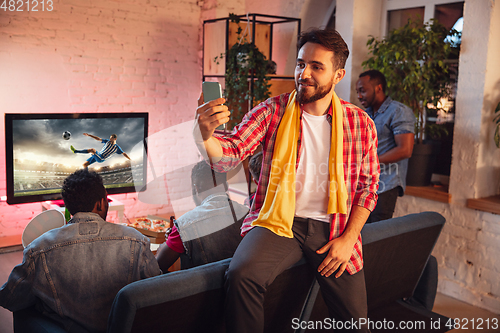 Image of Group of friends watching TV, sport match together. Emotional man cheering for favourite team, celebrating successful betting. Concept of friendship, leisure activity, emotions