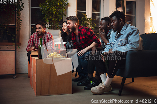 Image of Group of friends watching TV, sport match together. Emotional fans cheering for favourite team, watching on exciting game. Concept of friendship, leisure activity, emotions