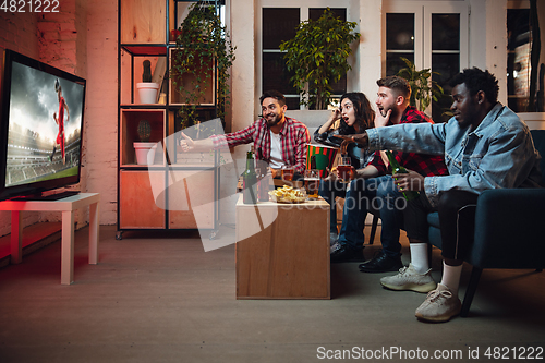 Image of Group of friends watching TV, sport match together. Emotional fans cheering for favourite team, watching on exciting game. Concept of friendship, leisure activity, emotions