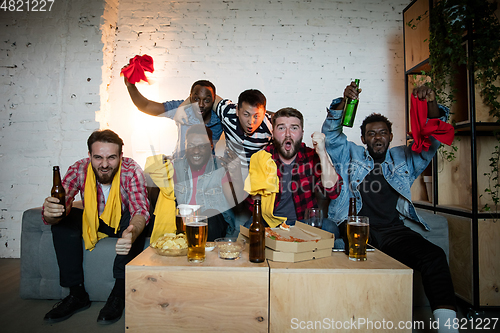 Image of Group of friends watching TV, sport match together. Emotional fans cheering for favourite team, watching on exciting game. Concept of friendship, leisure activity, emotions