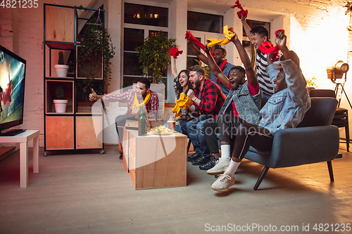 Image of Group of friends watching TV, sport match together. Emotional fans cheering for favourite team, watching on exciting game. Concept of friendship, leisure activity, emotions