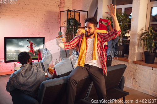 Image of Group of friends watching TV, sport match together. Emotional man cheering for favourite team, celebrating successful betting. Concept of friendship, leisure activity, emotions