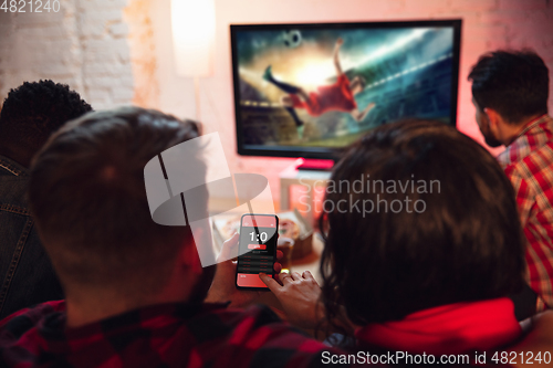 Image of Group of friends watching TV, sport match together. Emotional fans cheering for favourite team, watching on exciting game. Concept of friendship, leisure activity, emotions