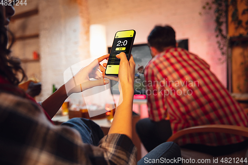 Image of Group of friends watching TV, sport match together. Emotional man cheering for favourite team, celebrating successful betting. Concept of friendship, leisure activity, emotions