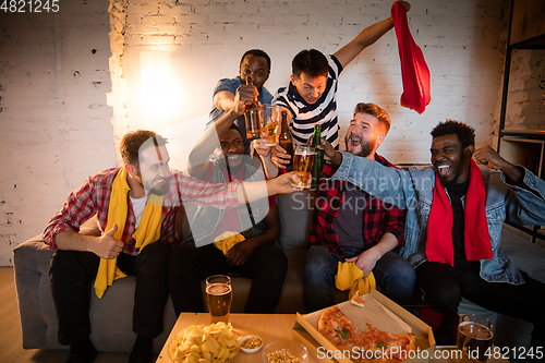 Image of Group of friends watching TV, sport match together. Emotional fans cheering for favourite team, watching on exciting game. Concept of friendship, leisure activity, emotions