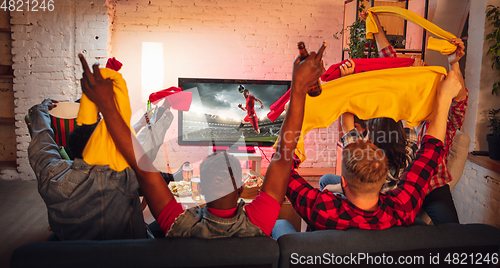 Image of Group of friends watching TV, sport match together. Emotional fans cheering for favourite team, watching on exciting game. Concept of friendship, leisure activity, emotions