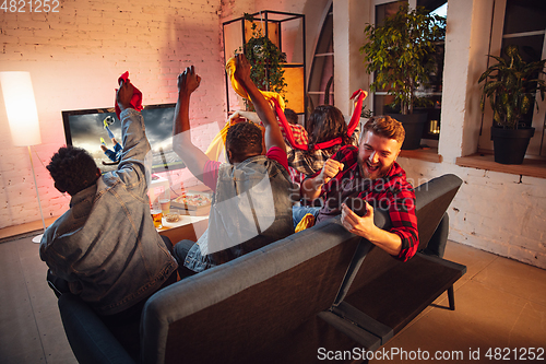 Image of Group of friends watching TV, sport match together. Emotional man cheering for favourite team, celebrating successful betting. Concept of friendship, leisure activity, emotions