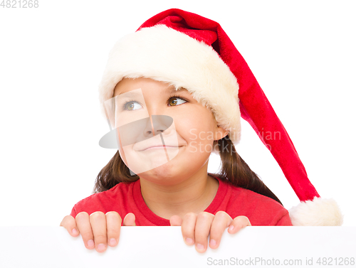 Image of Little girl in santa hat is holding blank board