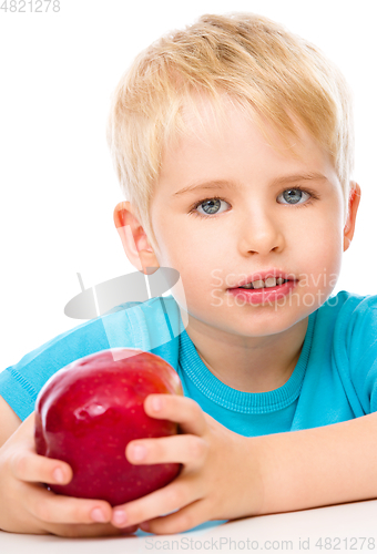 Image of Portrait of a cute little boy with red apple
