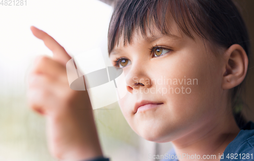 Image of Girl is drawing something on window