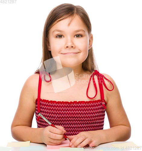 Image of Girl is writing on color stickers using pen