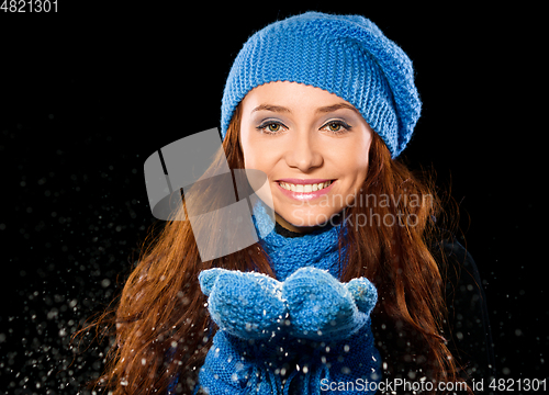 Image of Young happy woman under snowfall