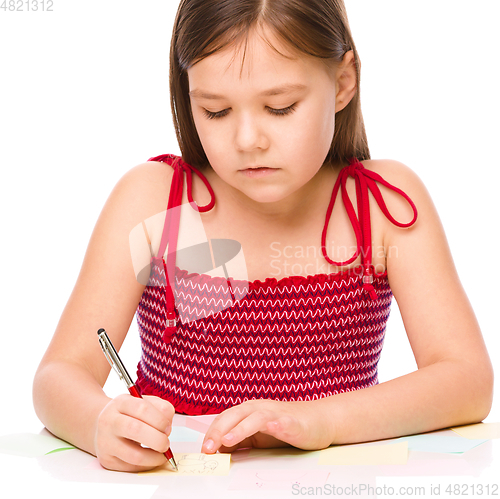 Image of Girl is writing on color stickers using pen