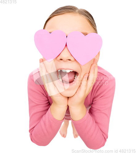 Image of Little girl is holding hearts over her eyes