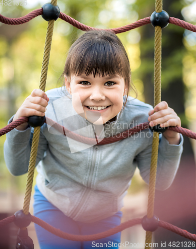 Image of Cute little girl is playing in playground