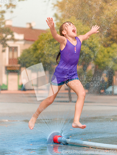 Image of Girl is enjoying fountain with cold water