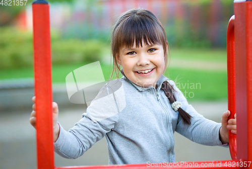 Image of Cute little girl is playing in playground