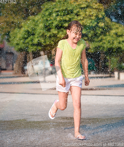 Image of Girl is running through fountains