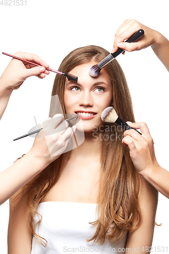 Image of beautiful girl with makeup brushes