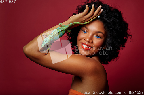 Image of beautiful woman holding chameleon