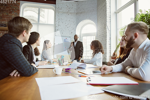 Image of Group of young business professionals having a meeting, creative office