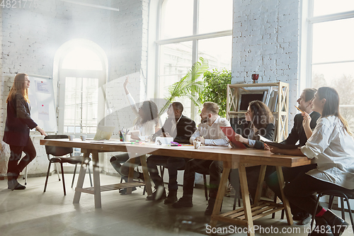 Image of Group of young business professionals having a meeting, creative office