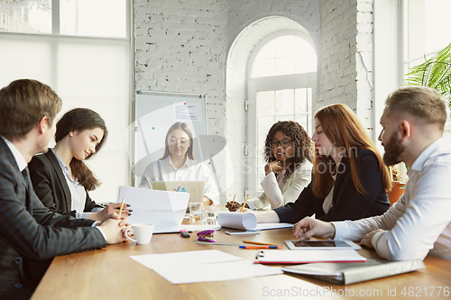 Image of Group of young business professionals having a meeting, creative office