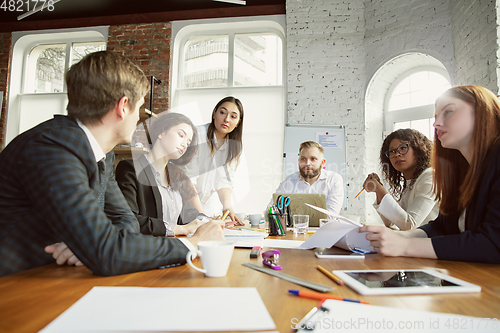 Image of Group of young business professionals having a meeting, creative office