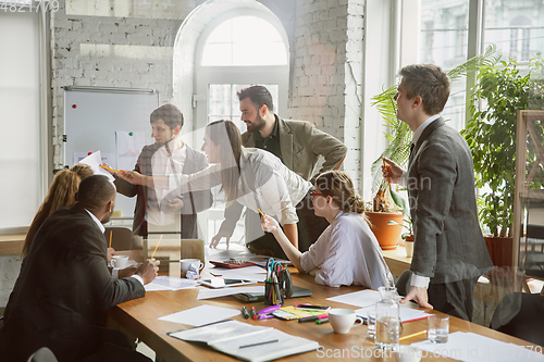 Image of Group of young business professionals having a meeting, creative office