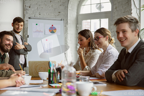 Image of Group of young business professionals having a meeting, creative office