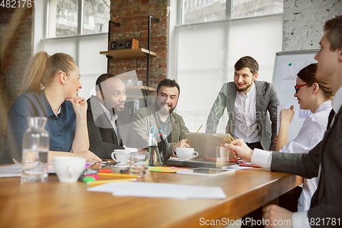 Image of Group of young business professionals having a meeting, creative office