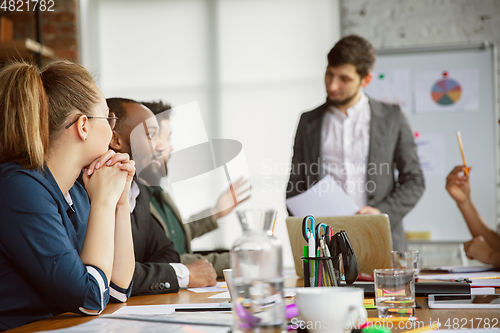 Image of Group of young business professionals having a meeting, creative office