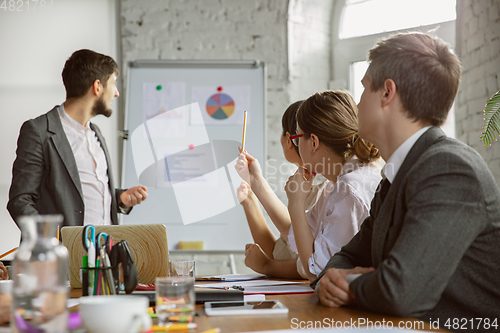 Image of Group of young business professionals having a meeting, creative office