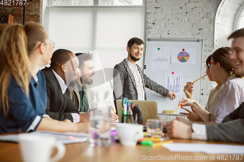 Image of Group of young business professionals having a meeting, creative office